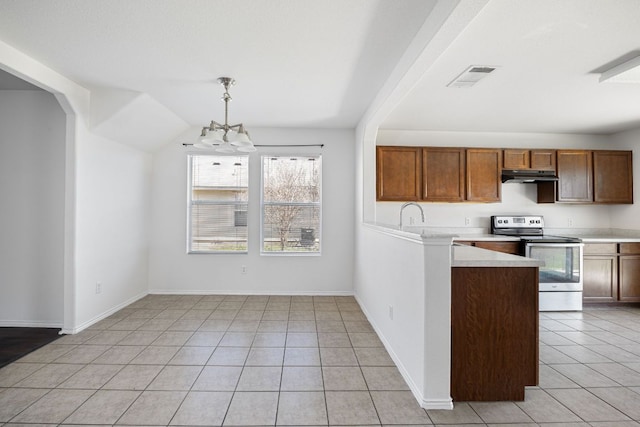 kitchen with under cabinet range hood, light countertops, light tile patterned floors, stainless steel range with electric cooktop, and a notable chandelier