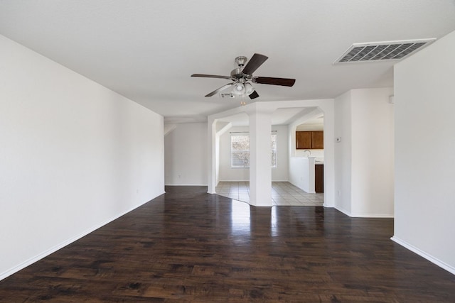 unfurnished living room with visible vents, baseboards, ceiling fan, and wood finished floors