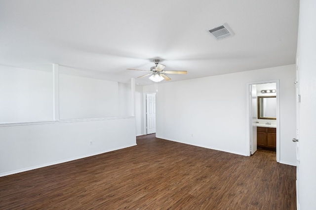 spare room with dark wood finished floors, baseboards, visible vents, and ceiling fan