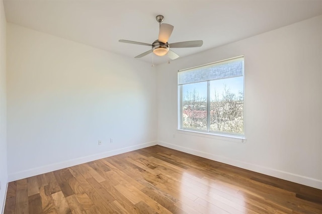 spare room with ceiling fan, baseboards, and wood finished floors