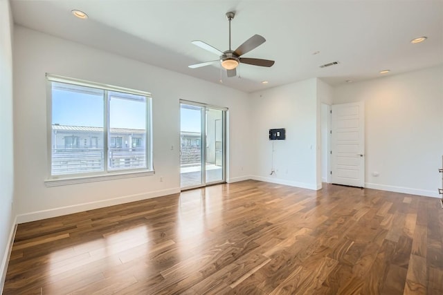 unfurnished living room featuring baseboards, wood finished floors, visible vents, and ceiling fan