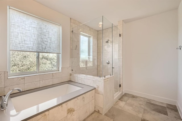 full bath featuring baseboards, a bath, and a shower stall