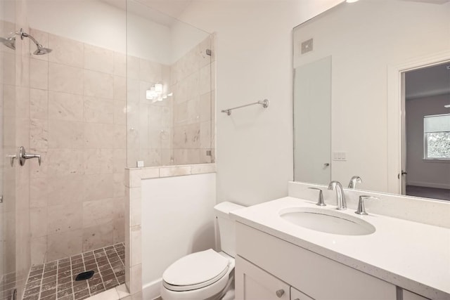 bathroom featuring visible vents, tiled shower, toilet, and vanity