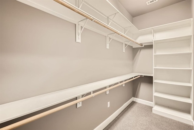 spacious closet featuring light colored carpet and visible vents