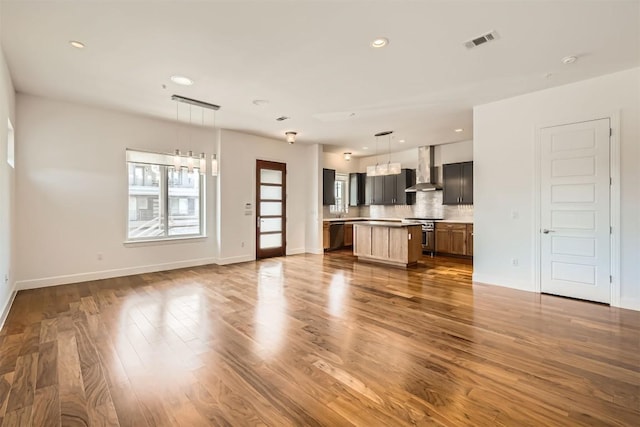 unfurnished living room with visible vents, recessed lighting, dark wood-type flooring, and baseboards