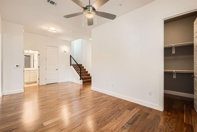 interior space featuring visible vents, ensuite bathroom, wood finished floors, a closet, and baseboards