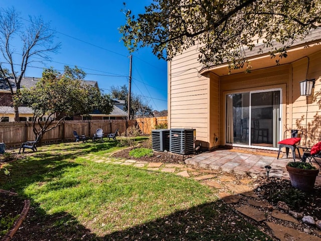 view of yard featuring a patio, central AC unit, and fence