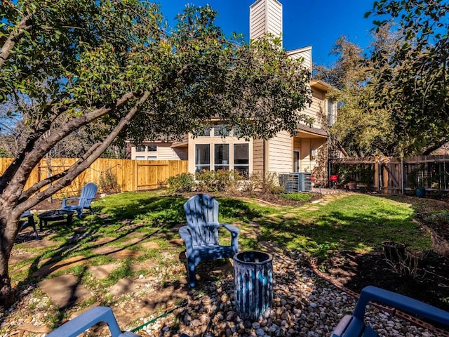 view of yard featuring a fenced backyard and central AC