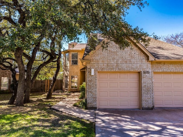 view of front of property with a garage, concrete driveway, and fence