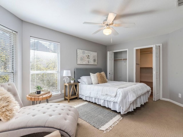 bedroom with visible vents, two closets, a ceiling fan, baseboards, and light colored carpet