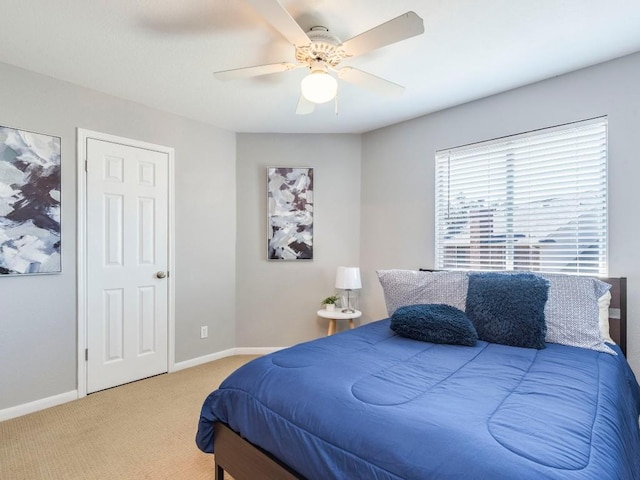 carpeted bedroom featuring baseboards and ceiling fan