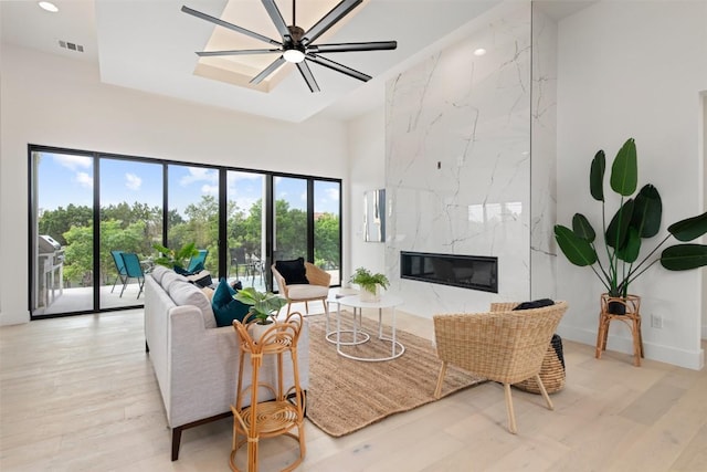 living area featuring a ceiling fan, wood finished floors, visible vents, recessed lighting, and a high end fireplace