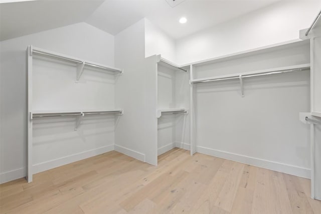 spacious closet featuring lofted ceiling and wood finished floors