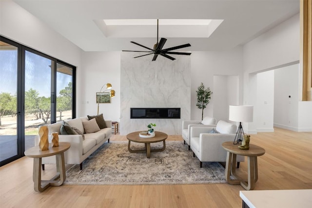 8112 Kuhn Dr, Austin, TX 78736 - living area featuring wood finished floors, a skylight, a high end fireplace, and a ceiling fan