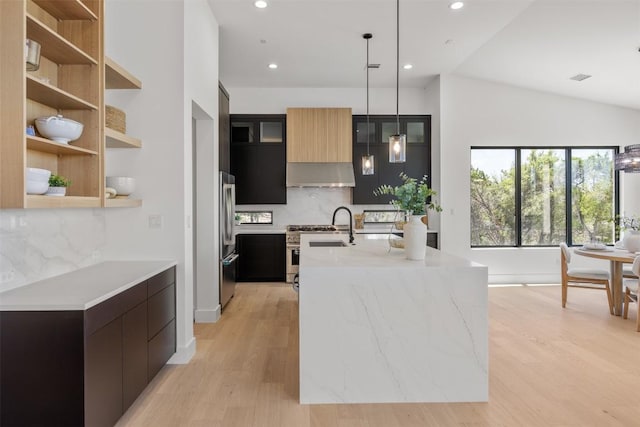 8112 Kuhn Dr, Austin, TX 78736 - kitchen featuring appliances with stainless steel finishes, modern cabinets, exhaust hood, backsplash, and light wood-type flooring
