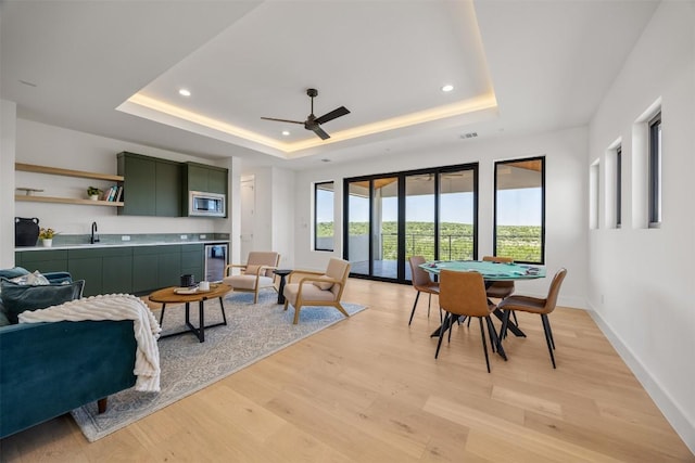 8112 Kuhn Dr, Austin, TX 78736 - living room with a tray ceiling, light wood-style floors, recessed lighting, ceiling fan, and wine cooler