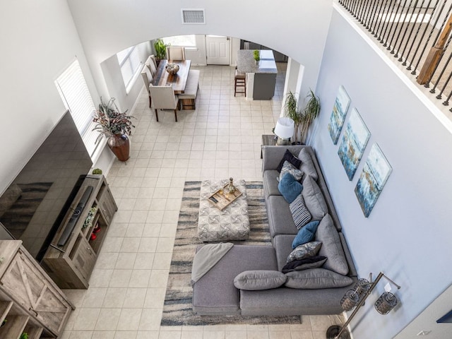 248 Brady Creek Way, Leander, TX 78641 - living room featuring arched walkways, light tile patterned flooring, and a towering ceiling