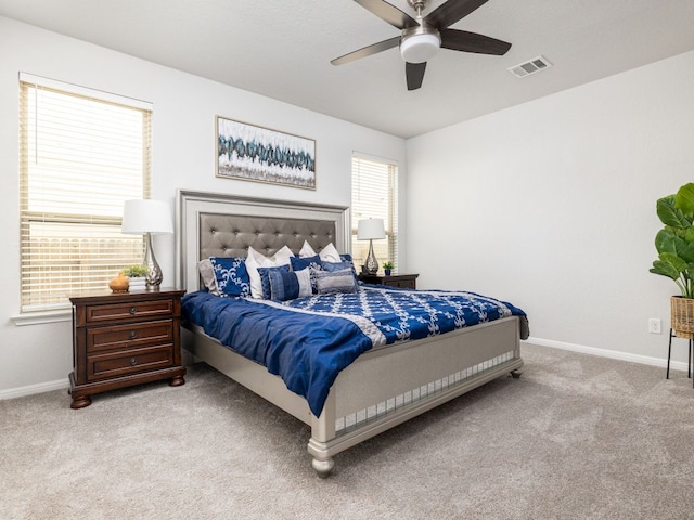 carpeted bedroom with visible vents, a ceiling fan, and baseboards