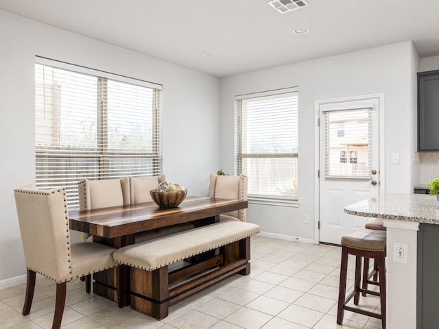 dining room featuring light tile patterned flooring, baseboards, and visible vents