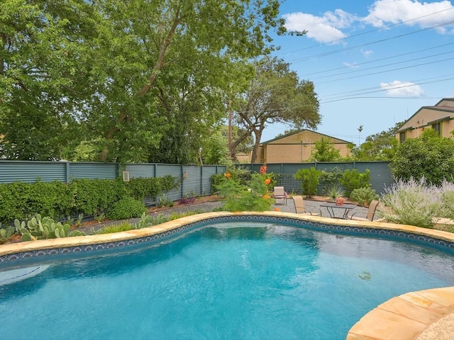 outdoor pool featuring a fenced backyard