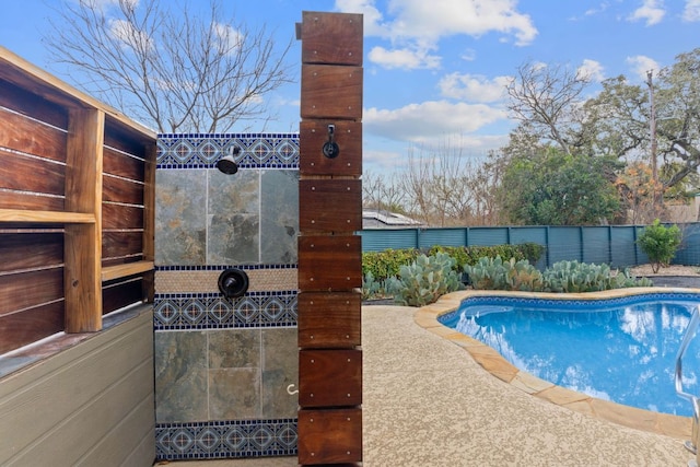 view of swimming pool with a fenced in pool and fence