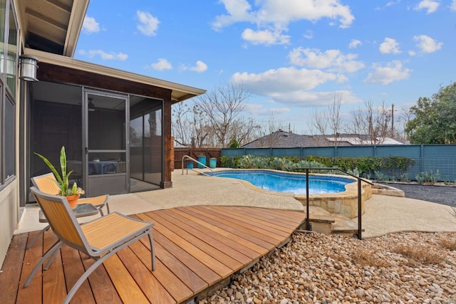 view of pool with a fenced in pool, fence, a patio area, and a sunroom