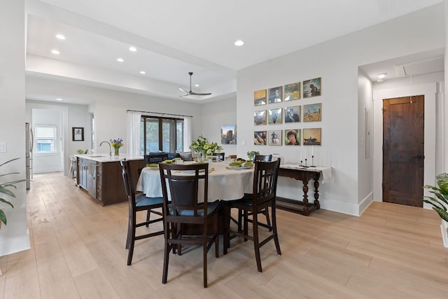 dining room featuring recessed lighting, a ceiling fan, light wood-type flooring, and a tray ceiling