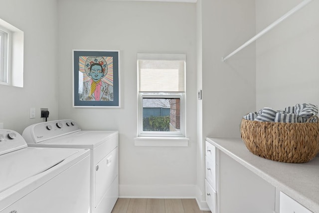 clothes washing area featuring washer and dryer, light wood-type flooring, cabinet space, and baseboards