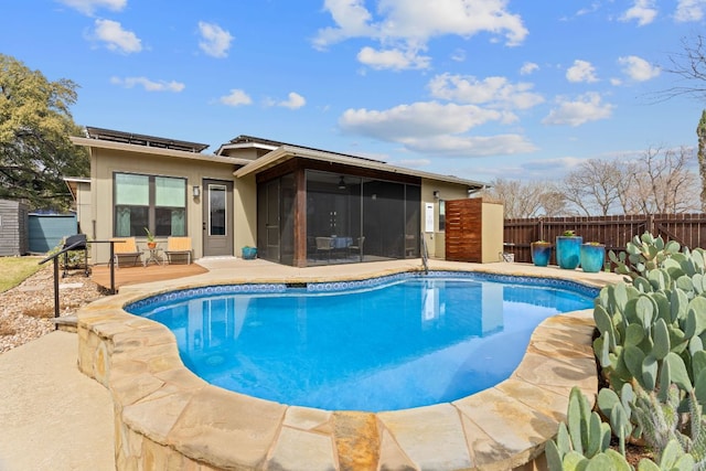 view of swimming pool featuring a patio area, fence, a fenced in pool, and a sunroom