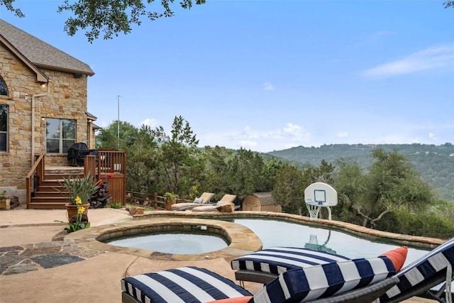 view of swimming pool featuring a deck, an in ground hot tub, and a patio