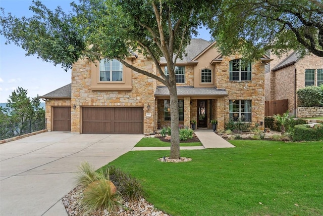 traditional-style house featuring a front lawn, stone siding, fence, concrete driveway, and a shingled roof