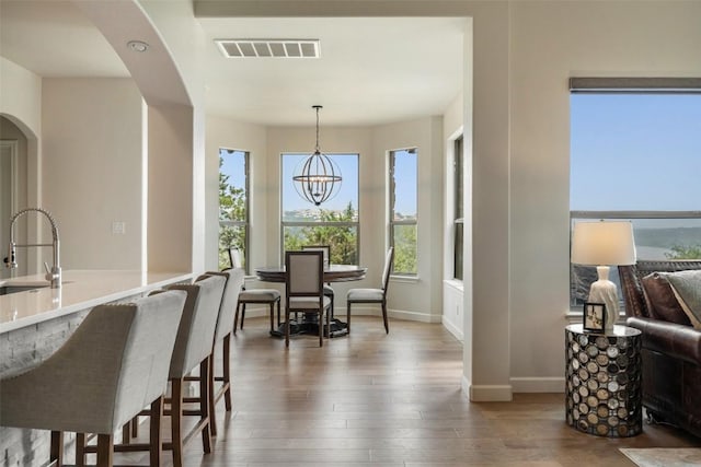 dining room with visible vents, plenty of natural light, and wood finished floors