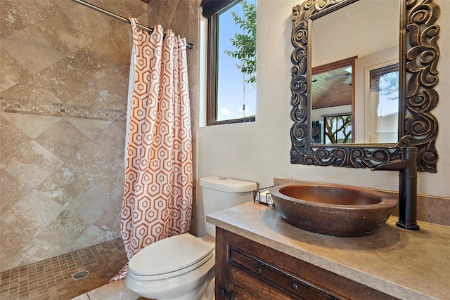 bathroom featuring toilet, vanity, and a tile shower