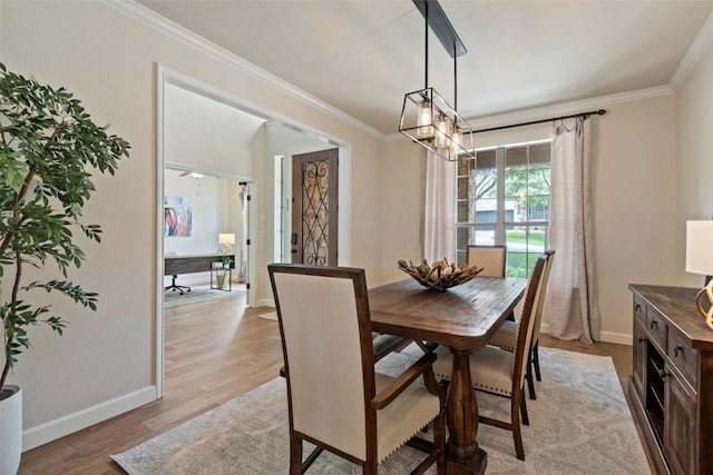 dining room with baseboards, light wood-style floors, an inviting chandelier, and ornamental molding