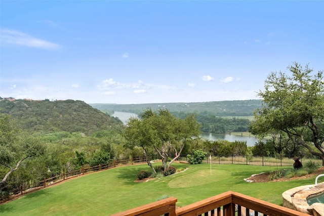 view of property's community with a yard, a water view, and fence