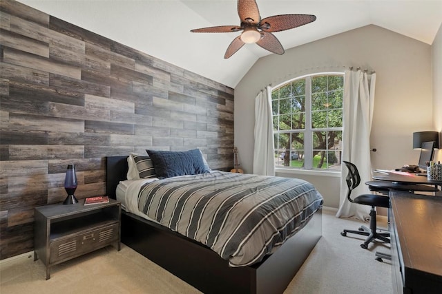 bedroom with wooden walls, lofted ceiling, ceiling fan, an accent wall, and light colored carpet