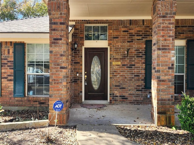 view of exterior entry featuring brick siding