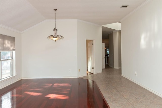 unfurnished room with visible vents, crown molding, baseboards, lofted ceiling, and wood finished floors