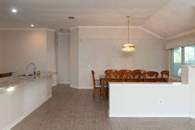 tiled dining room with a sink, visible vents, crown molding, and vaulted ceiling