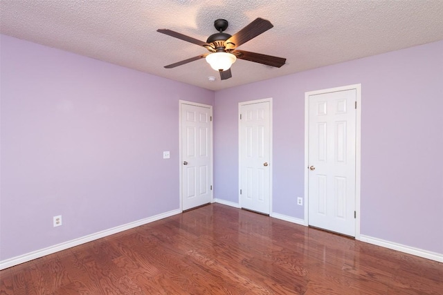 unfurnished bedroom featuring a textured ceiling, a ceiling fan, baseboards, and wood finished floors