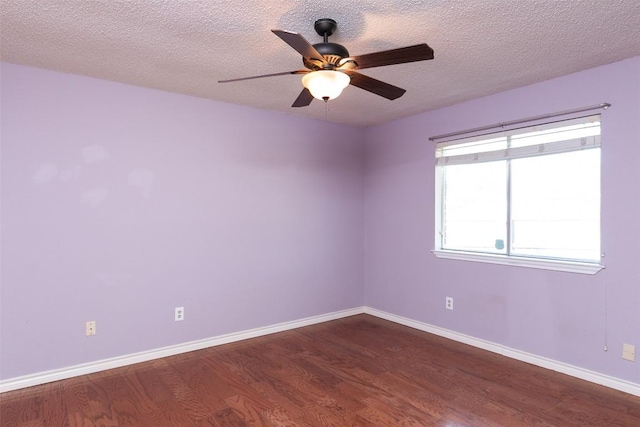 spare room featuring ceiling fan, baseboards, and dark wood-style floors