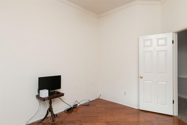 interior space with crown molding, baseboards, and wood finished floors