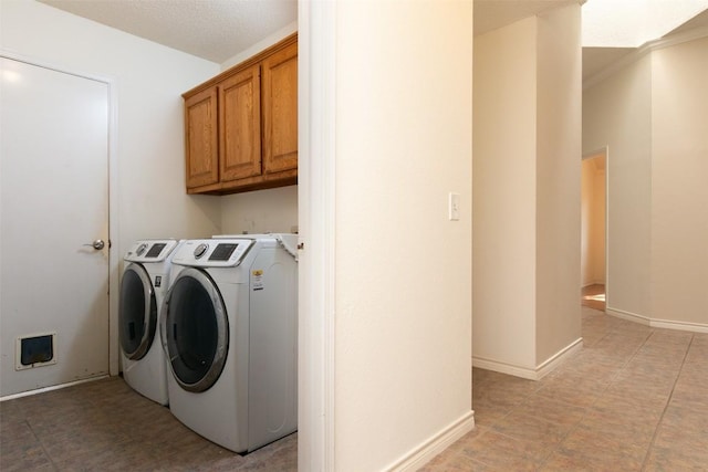 laundry room featuring baseboards, cabinet space, and separate washer and dryer