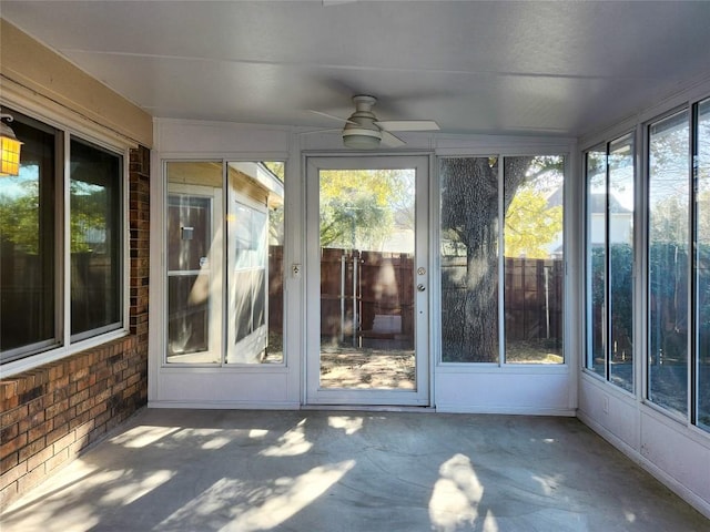 unfurnished sunroom featuring a ceiling fan