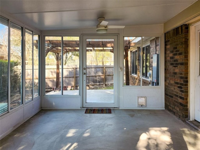 unfurnished sunroom with plenty of natural light and a ceiling fan