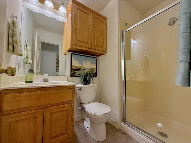 bathroom with a shower stall, toilet, tile patterned flooring, and vanity