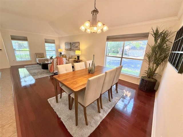 dining space featuring wood finished floors, crown molding, a chandelier, and baseboards