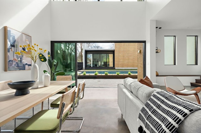 living room with concrete flooring and a towering ceiling