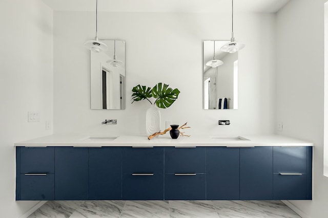 full bath featuring a sink, marble finish floor, and double vanity