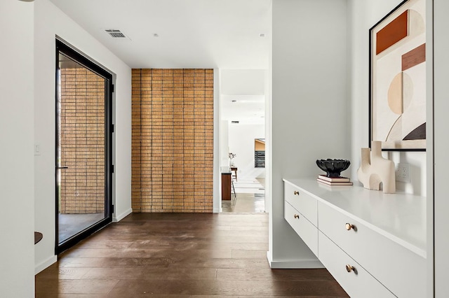 hallway featuring visible vents and dark wood-style flooring